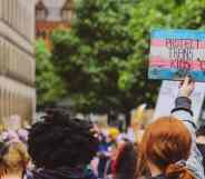 Person holds a sign that reads "Protect trans kids"