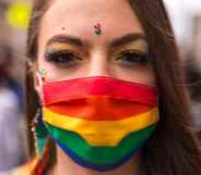 A person wearing a rainbow face covering