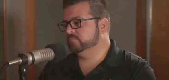 Headshot of Tommy Reyes speaking into a microphone