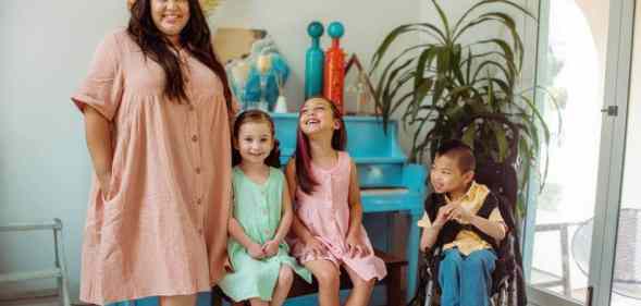 A photo of The McLeod Family consisting of mum Eeka McLeod and her three children Ella, Evan and Eli smiling at the camera or up at her