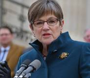 Kansas governor Laura Kelly addresses a crowd as she stands at a podium