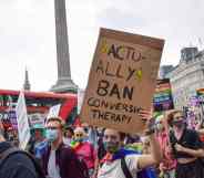 A demonstrator holds a placard that says "Actually Ban Conversion Therapy" in Trafalgar Square during the Reclaim Pride protest