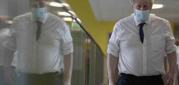 Boris Johnson walks through a hospital corridor