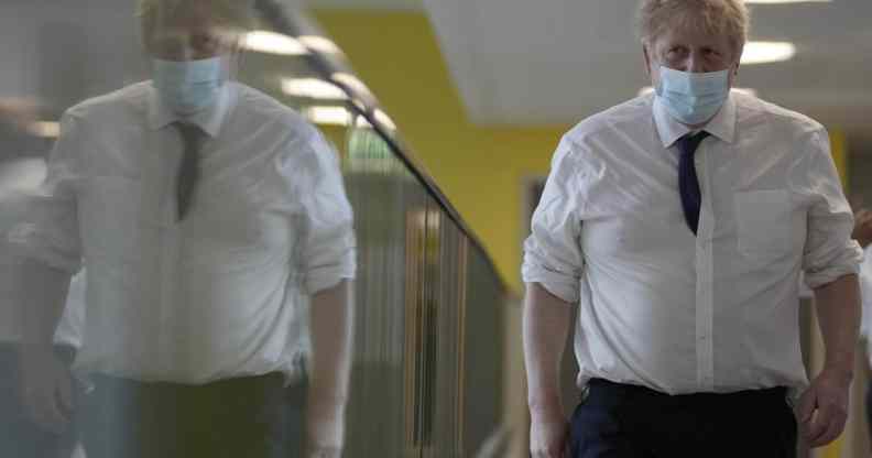 Boris Johnson walks through a hospital corridor