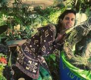 Fern Feather, a white trans woman, is seen surrounded by plants