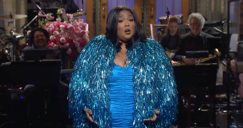 Lizzo wears a bright blue dress and a sparkly blue jacket during her opening monologue on Saturday Night Live