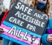 Two people are holding placards in support of trans people, during the demonstration for better transgender health care organized in Amsterdam