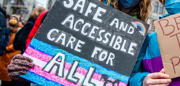 Two people are holding placards in support of trans people, during the demonstration for better transgender health care organized in Amsterdam