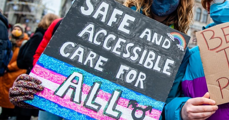 Two people are holding placards in support of trans people, during the demonstration for better transgender health care organized in Amsterdam