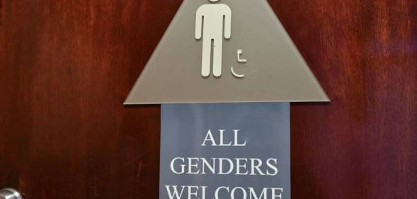 A bathroom sign with a smaller sign that reads "All genders welcome"