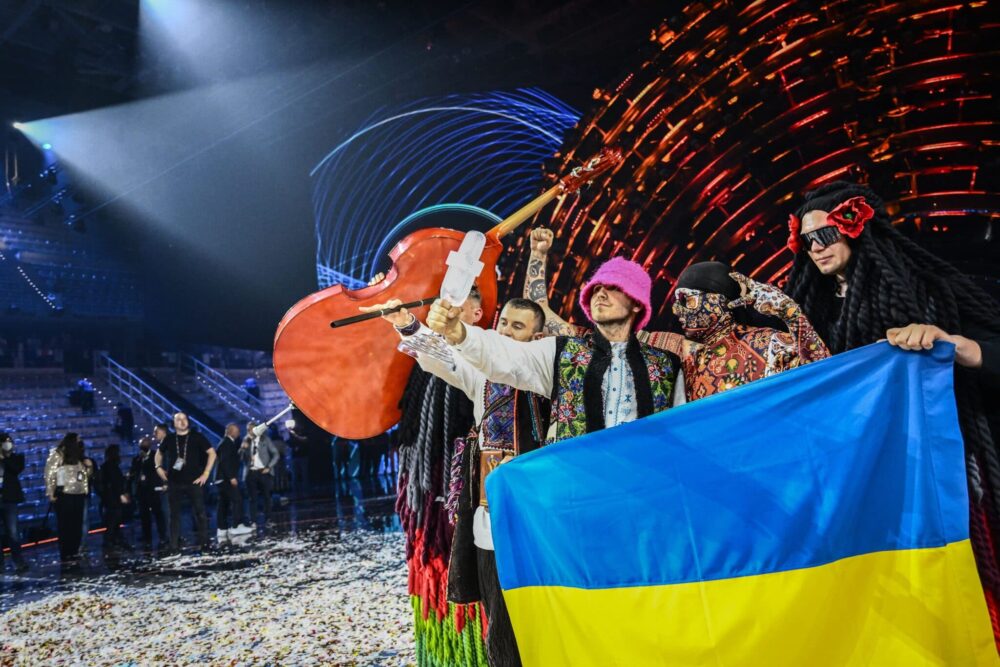 Ukraine's Kalush Orchestra hold the Eurovision trophy and a Ukraine flag