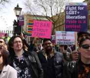 Demonstrators hold placards during the No Ban Without Trans protest