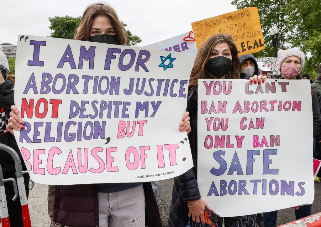 Marchers hold up signs during a Mother's Day rally in support of Abortion rights at the U.S. Supreme Court.