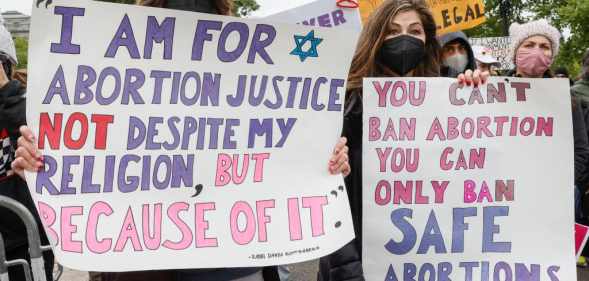 Marchers hold up signs during a Mother's Day rally in support of Abortion rights at the U.S. Supreme Court.