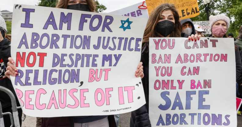 Marchers hold up signs during a Mother's Day rally in support of Abortion rights at the U.S. Supreme Court.