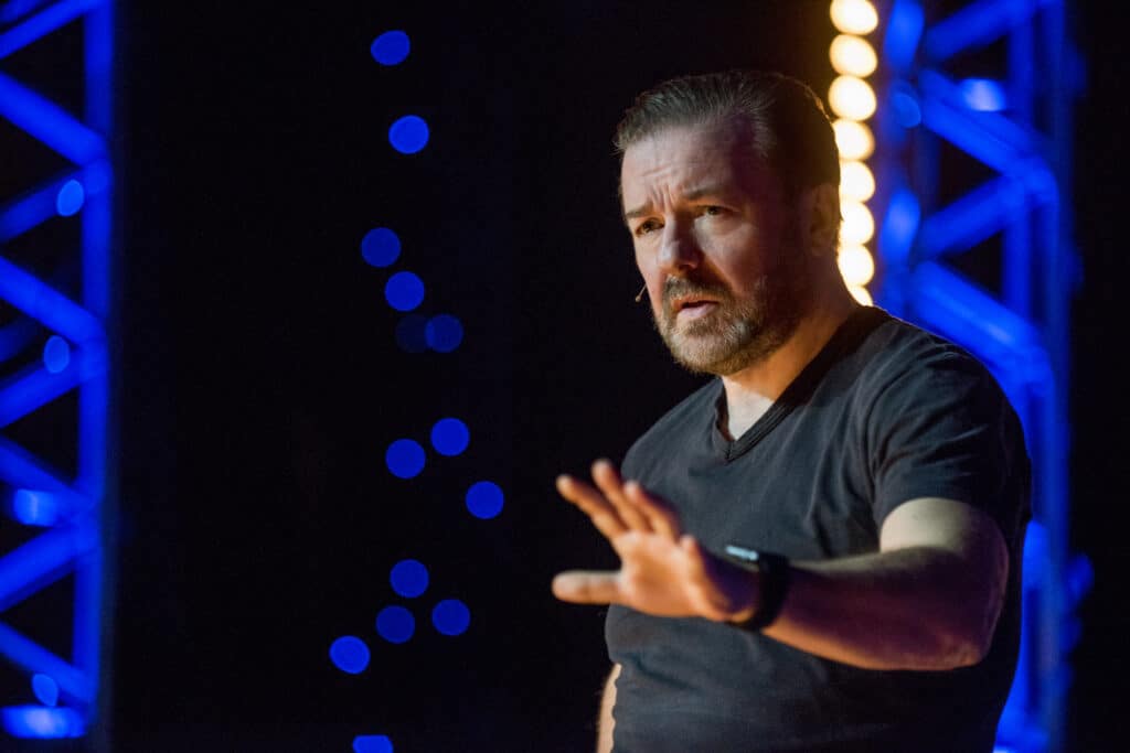 Ricky Gervais gestures while performing on stage