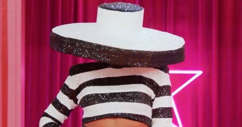 A drag queen appears on Drag Race All Stars 7 wearing a black and white outfit with a giant hat