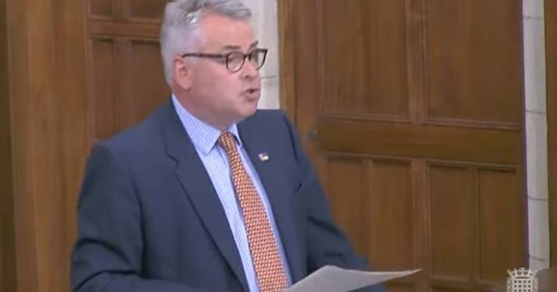 Tory MP Tim Loughton wears a blue shirt, orange tie and dark blue suit jacket during a parliament debate on non-binary legal recognition