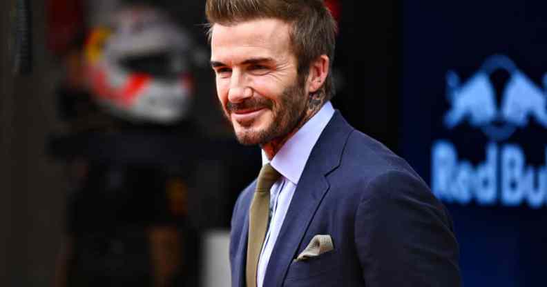 David Beckham wearing a suit, smiling