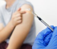 A doctor holds a syringe.