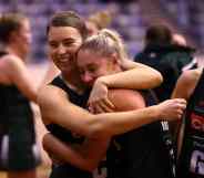 Two netball players embrace