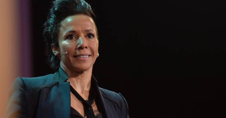 Dame Kelly Holmes wears a black top, black blazer and matching tie as she speaks to people off camera