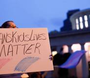 A transgender rights advocate holds a sign that reads '#TransKidsLives Matter' with pink and blue colours underneath as they outside the Ohio Statehouse during a rally against a trans sports ban bill