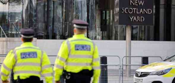 Two British police offices walk outside New Scotland Yard the home of the Metropolitan Police in London