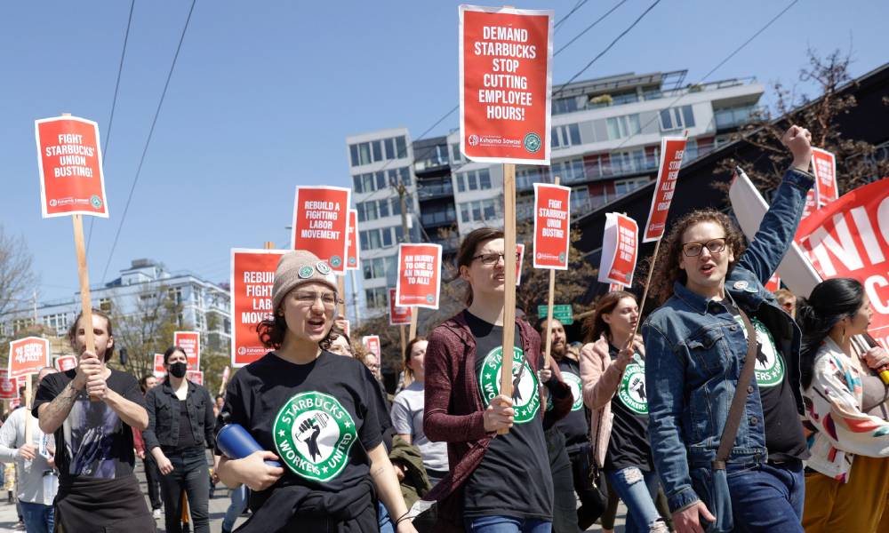 Several people gather in a crowd to protest against Starbucks and support staff who want to unionise