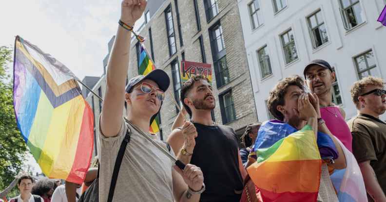 People walk through Oslo holding Pride flags