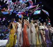 Contestants stand over the Miss International Queen 2022 Transgender Beauty Contest sign on stage