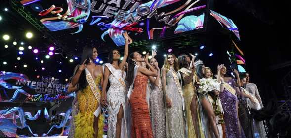 Contestants stand over the Miss International Queen 2022 Transgender Beauty Contest sign on stage