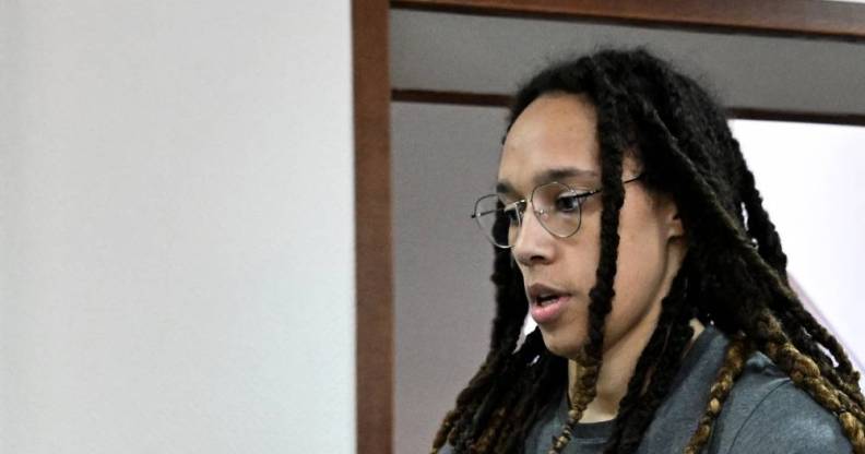 Brittney Griner wears a grey shirt and has her hair in locks as she walks to a preliminary court hearing in Russia