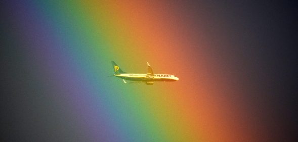 A plane of the Irish low cost company Ryanair flies in front of a rainbow