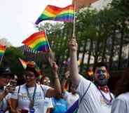 Revelers hold up LGBTQ+ Pride flags as they participate in the Philadelphia LGBT Pride Parade through the city's "Gayborhood" and downtown historic district in Pennsylvania