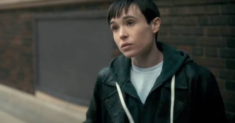 Elliot Page appears as his character from the Netflix show The Umbrella Academy. The character, Viktor, is wearing a white t-shirt and blue hooded sweatshirt as he stands outside and talks to someone off screen