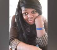 Brazil Johnson, a Black trans woman, wears a brown shirt and blue band on her write as she poses for a picture