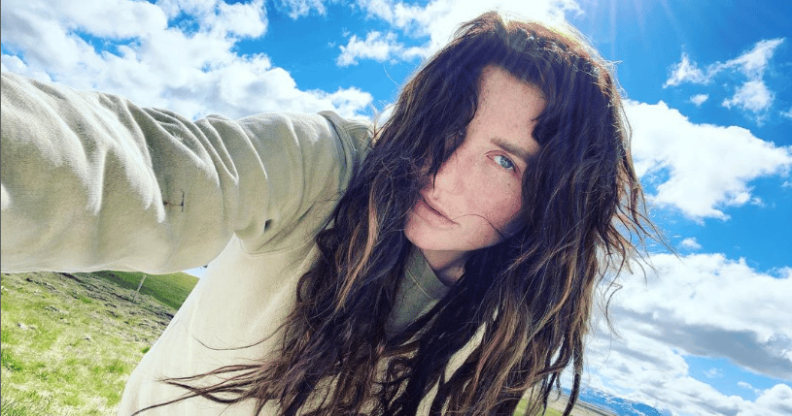 A selfie of Kesha. She's holding the camera, wearing a light hoody, standing in front of a blue but cloudy sky