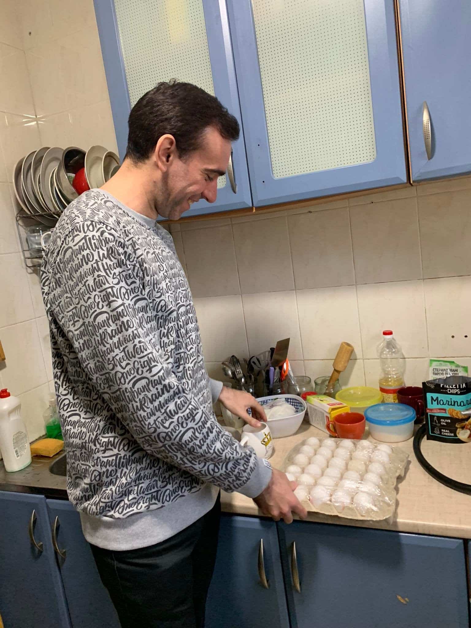 An LGBTQ+ person prepares food in a shelter.