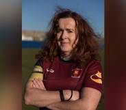 Alix Fitzgerald is seen wearing a red rugby jersey as she crosses her arms in front of her chest