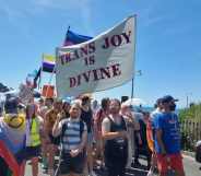 A protester holds a flag that reads 'trans joy is divine' at Trans Pride Brighton