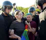 Russian riot police detained gay rights activists holding a LGBTQ+ rainbow flag