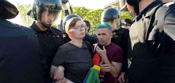 Russian riot police detained gay rights activists holding a LGBTQ+ rainbow flag