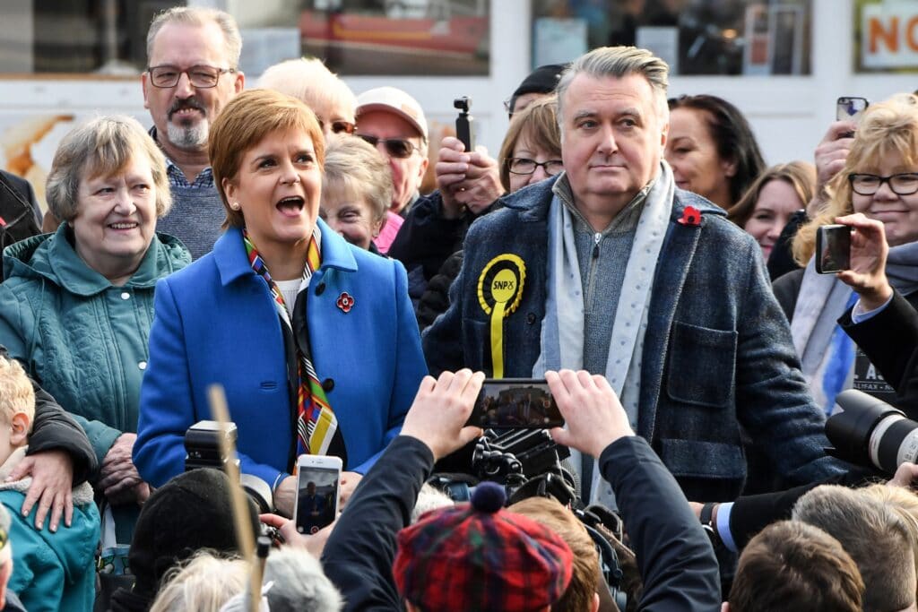 Nicola Sturgeon (centre left) stands to the side of John Nicolson 