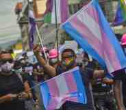 Demonstrators hold up flags while chanting slogans during the demonstration.