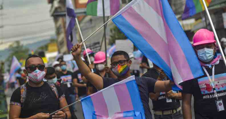 Demonstrators hold up flags while chanting slogans during the demonstration.