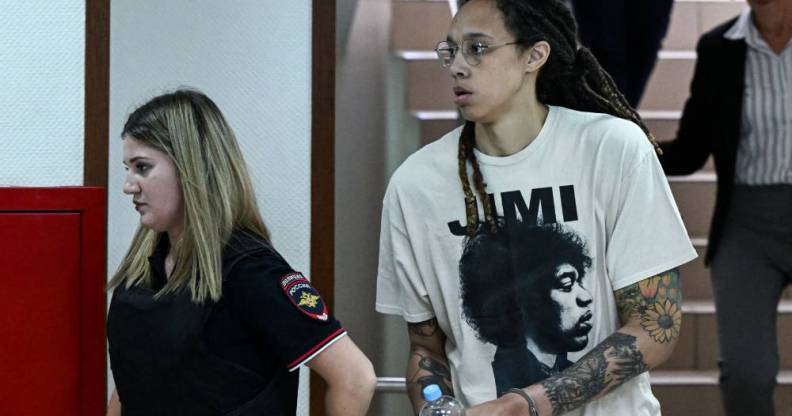 Brittney Griner wears white t-shirt as she is led out in handcuffs to a trial hearing in Russia