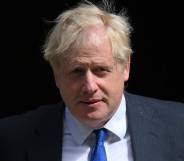 Prime minister Boris Johnson wears a white button up shirt, blue tie and grey-blue suit jacket