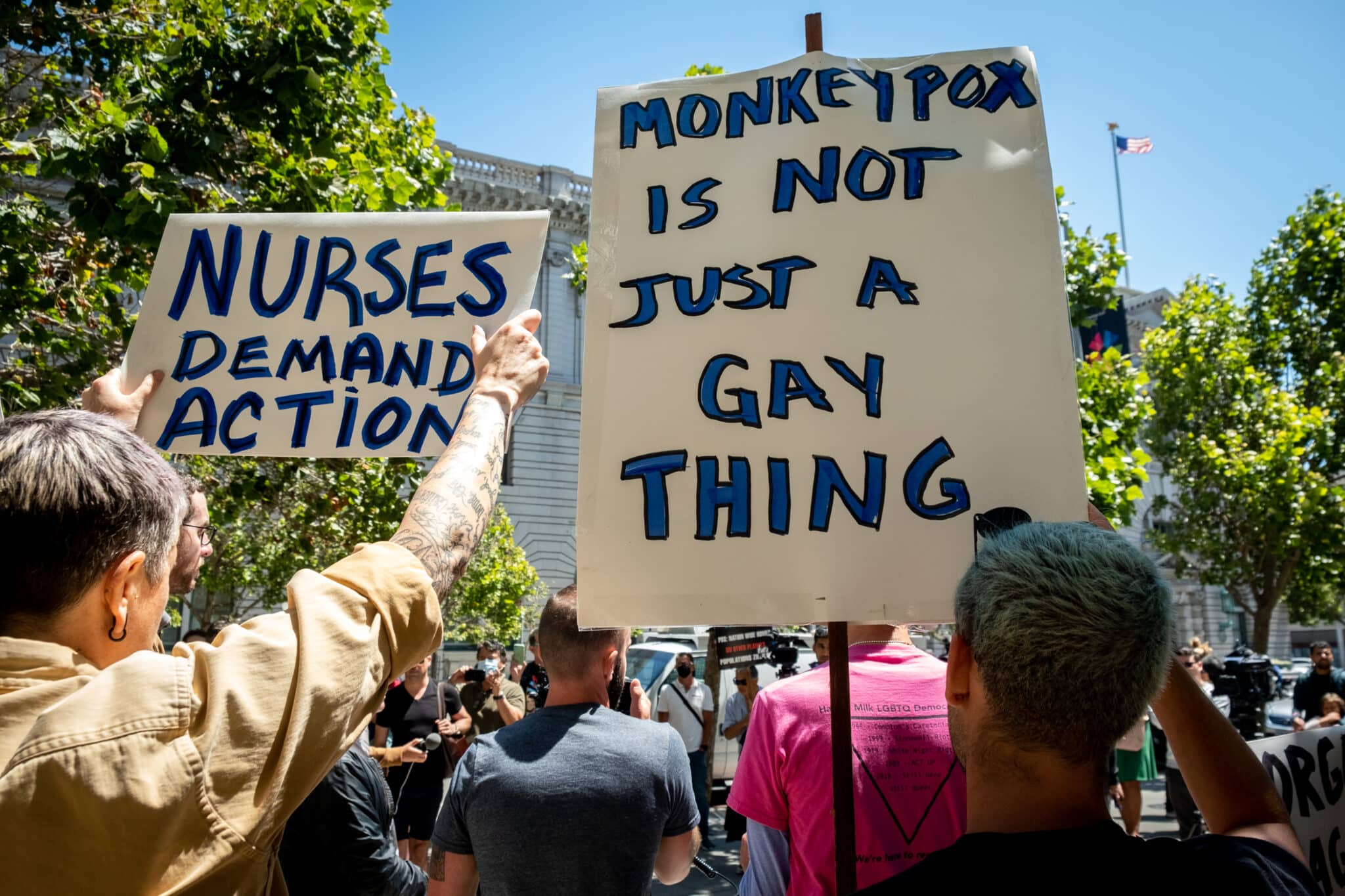 A person holds a sign reading: 'Monkeypox is not just a gay thing'