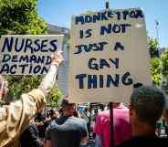 A person holds a sign reading: 'Monkeypox is not just a gay thing'